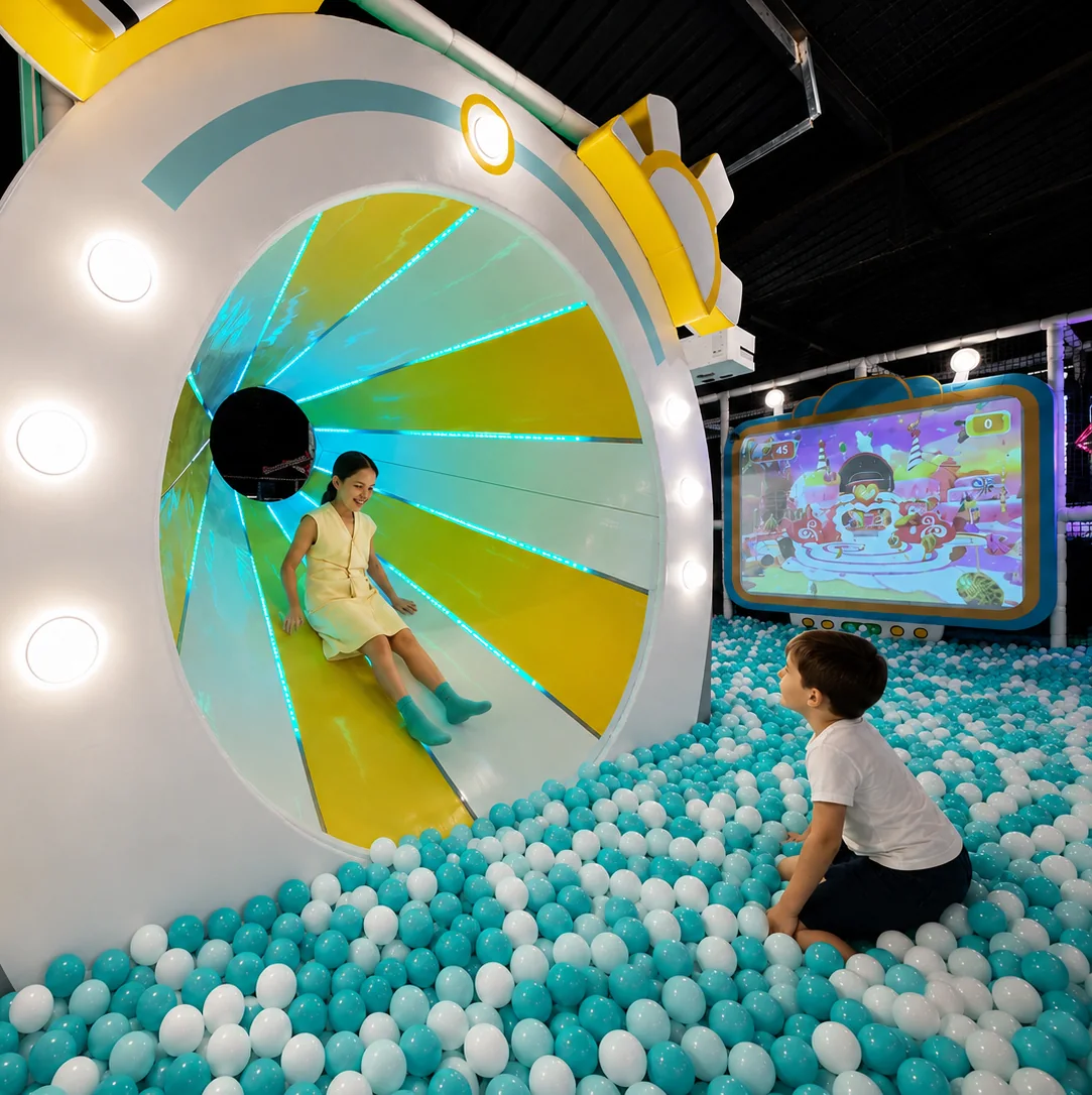 Peques disfrutando de una atracción junto a una piscina de bolas